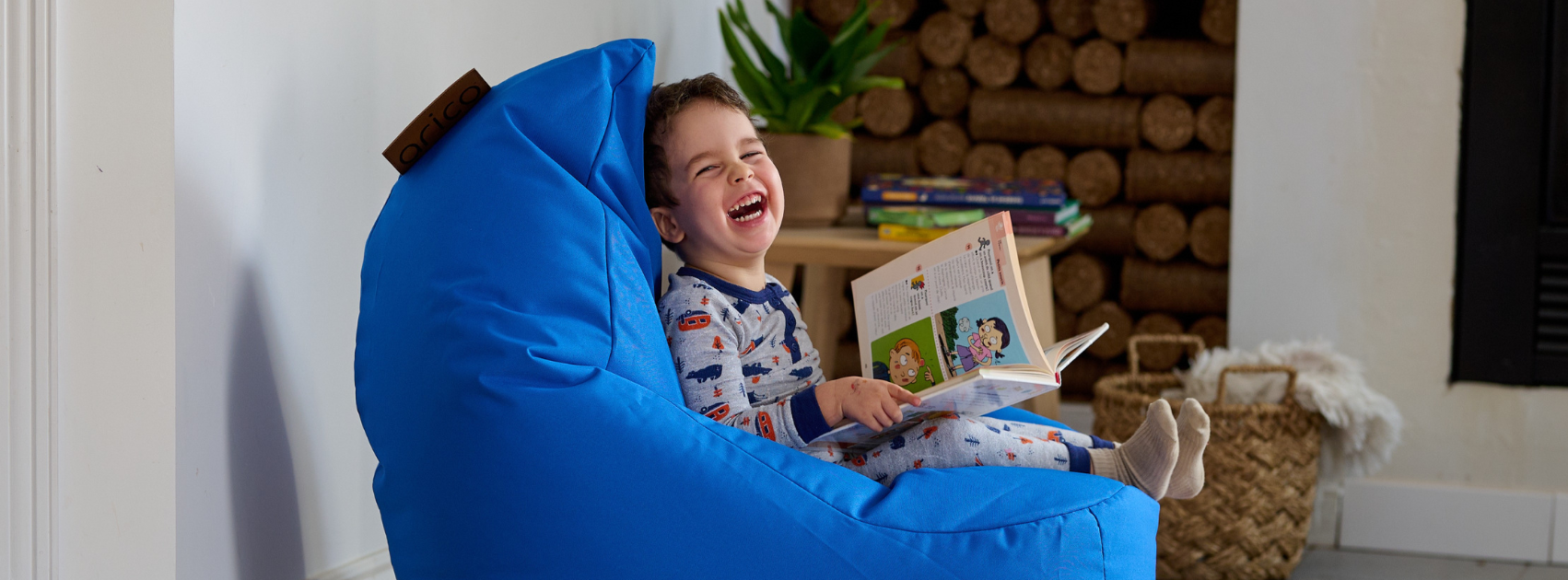 Un jeune enfant assis dans un bean bag ARICO, et prend du plaisir, coin lecture