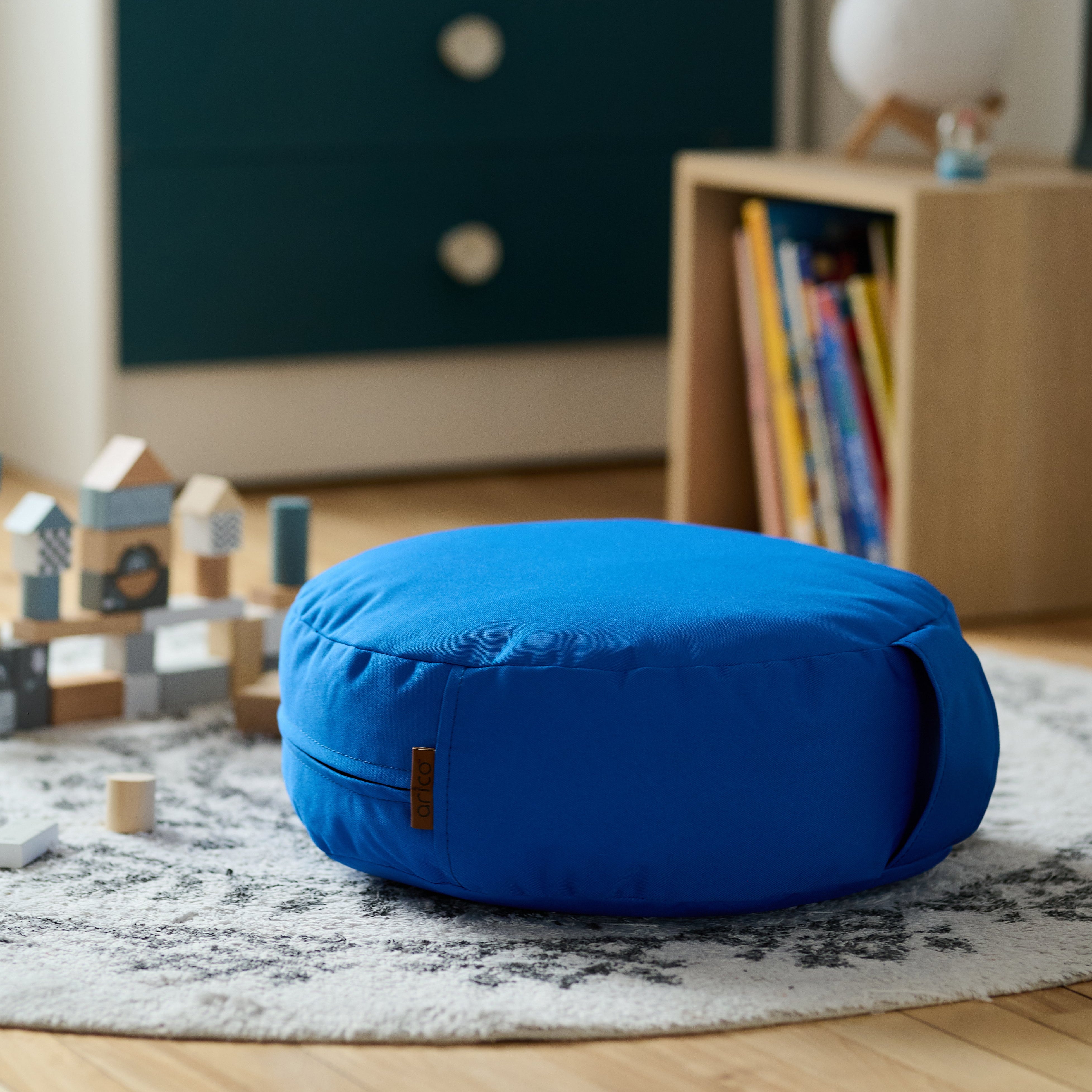 Un coussin de sol ARICO, dans une chambre d'enfant, parfait pour se mettre au niveau des enfants alors qu'ils jouent au sol.