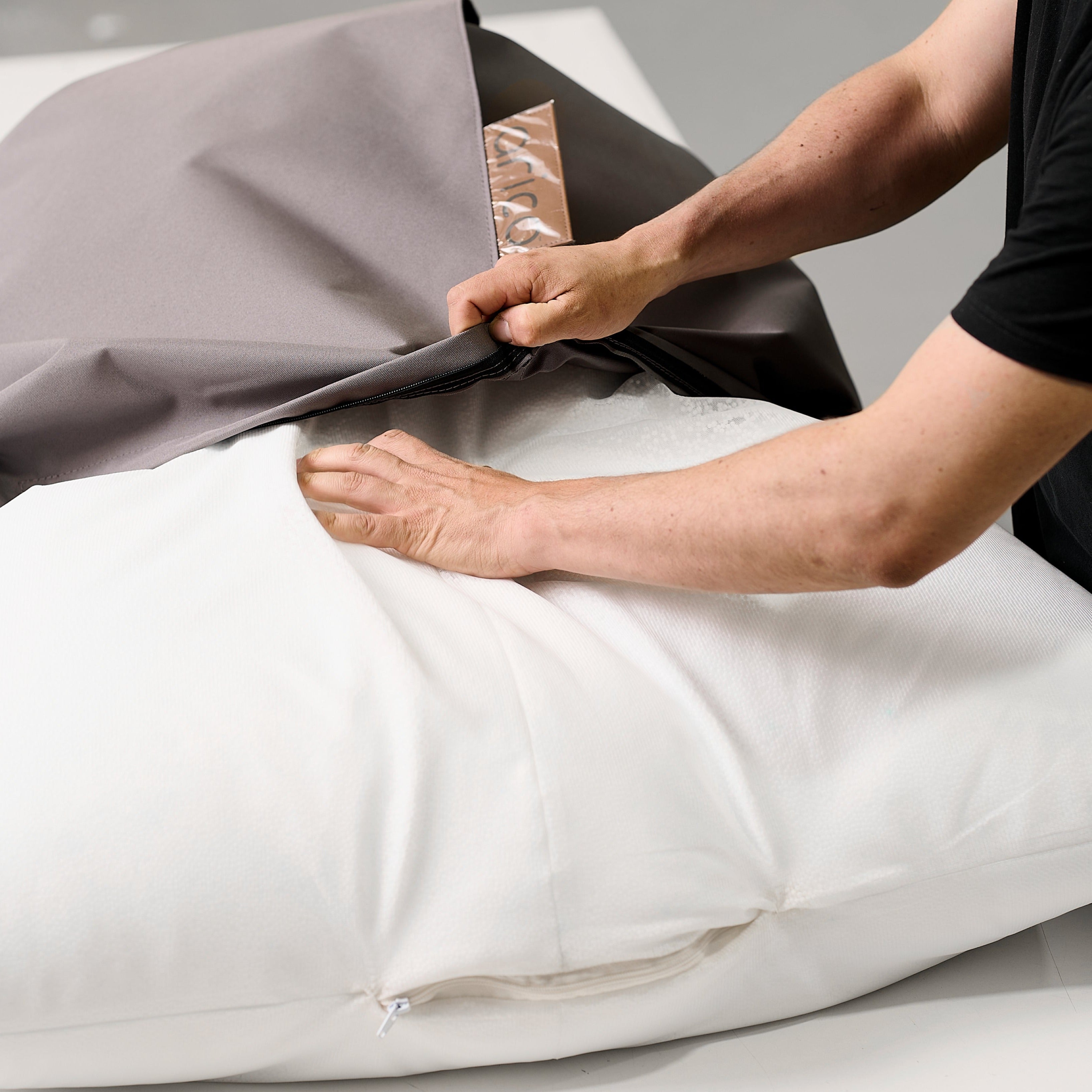 Montage d'un bean bag ARICO_photo du rembourrage ARICO dans un sac filet interne qui est inséré dans la housse ARICO couleur Charbon.