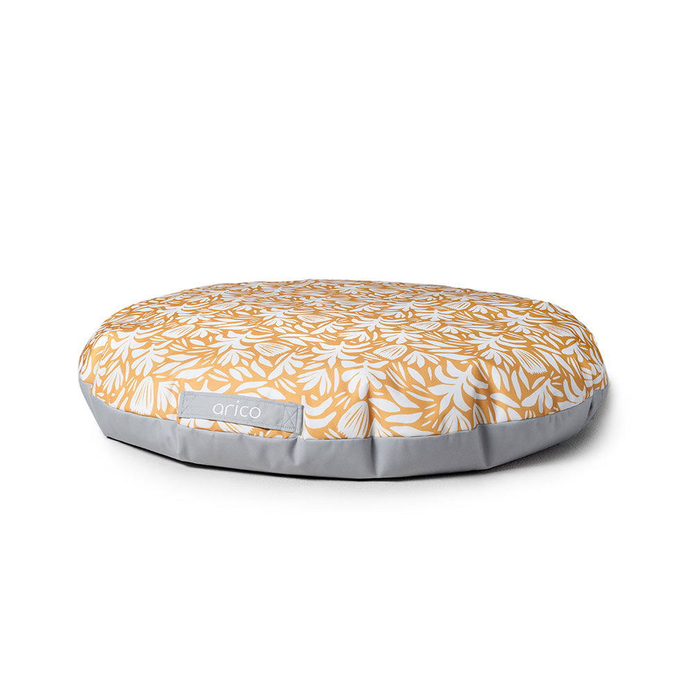 Coussin de sol Arico avec motif Flora sur fond blanc.