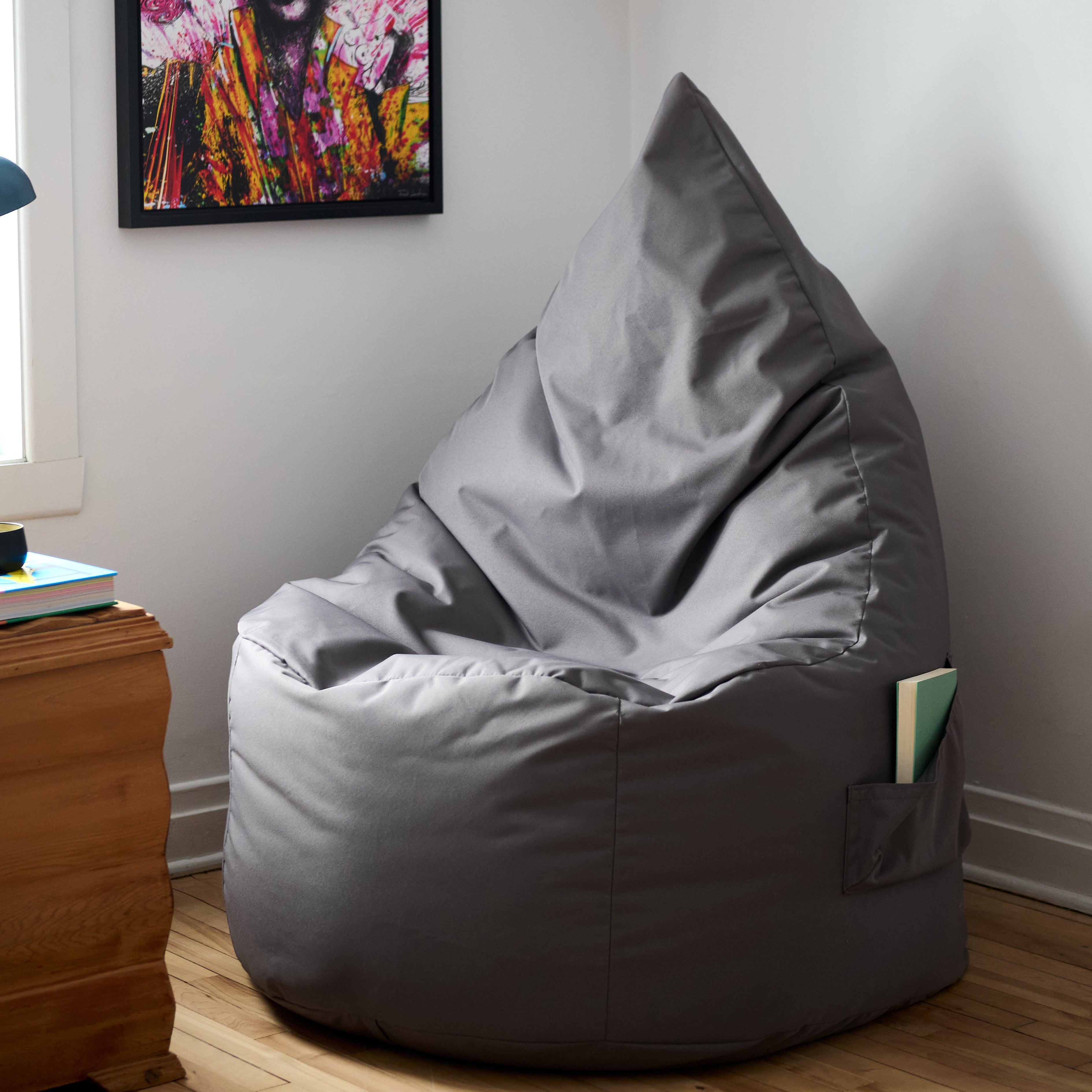 Un bean bag ARICO Ergo Adulte dans un coin lecture, pour s'y asseoir confortablement durant de long moments. 