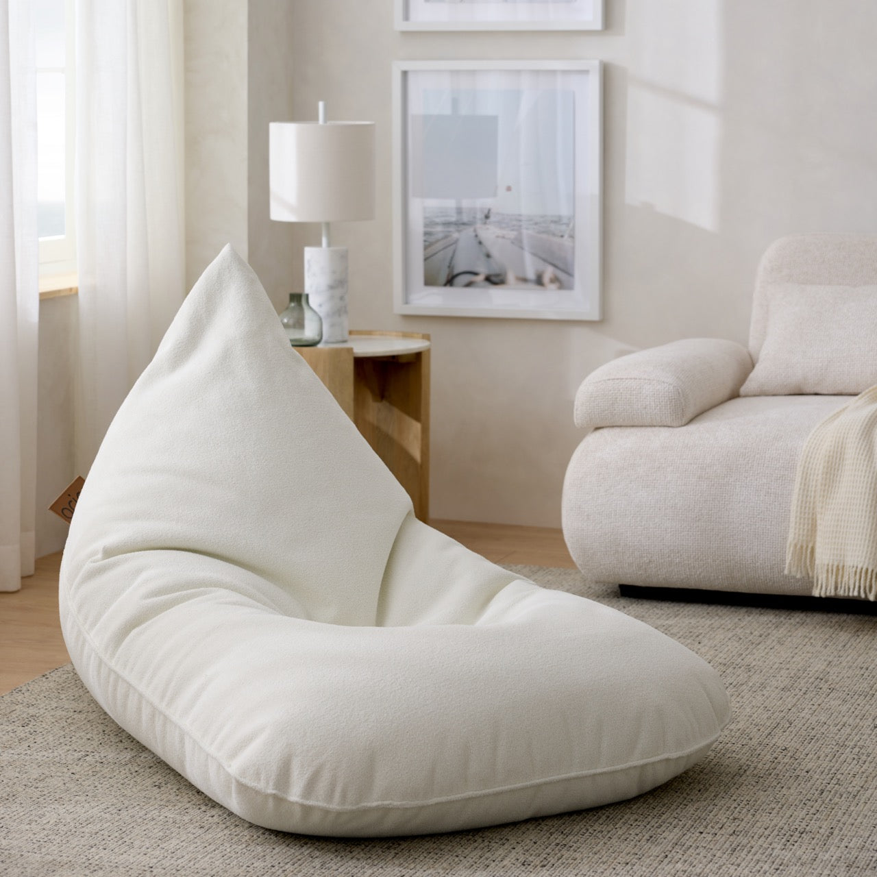Coin détente, espace confortable dans un salon au design clair, teinte pastel, blanc et beige, pour un look épuré et un confort imbattable.