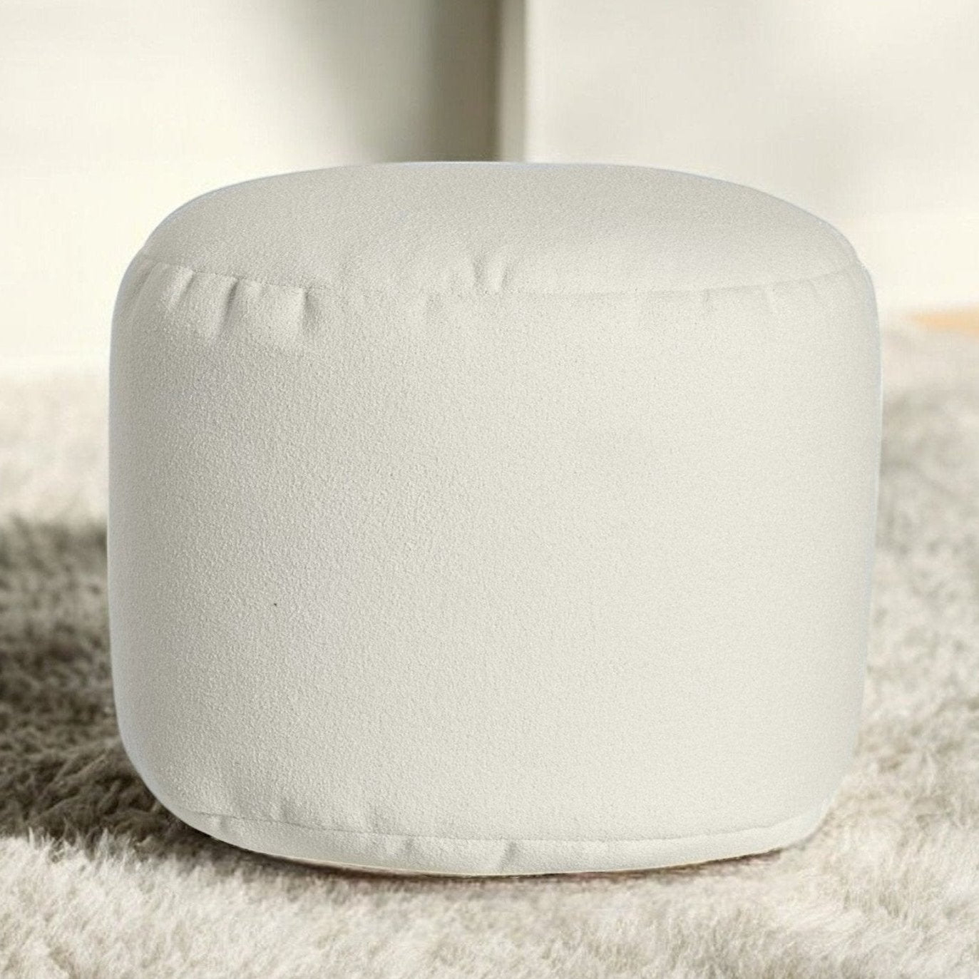 Un pouf repose pieds ARICO Ottoman de couleur Blanc Nuage sur un tapis doux déco design interieur