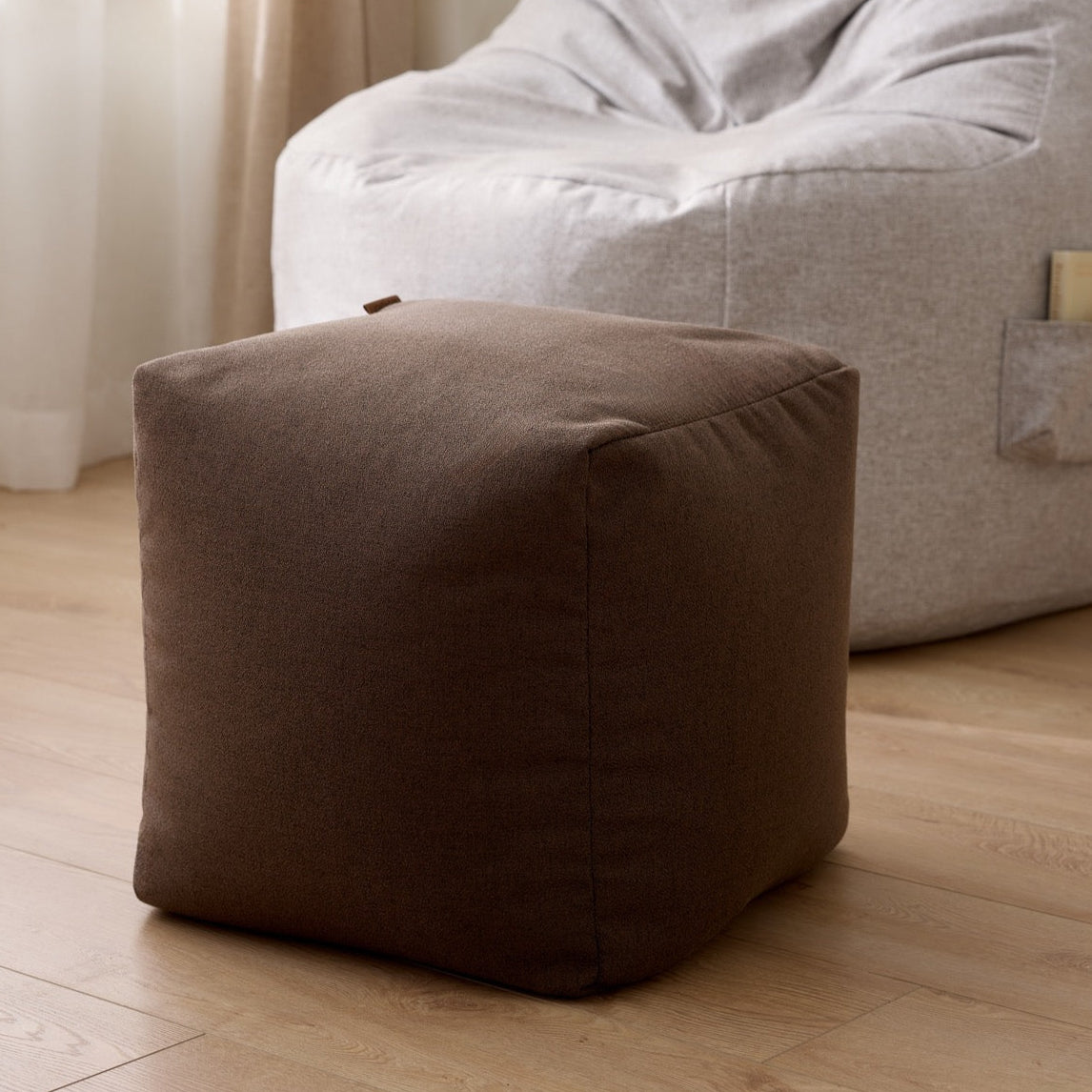 Un ajout de confort dans un salon au design sobre, luxueux, teinte chaude, pouf repose pieds ARICO haute qualité.