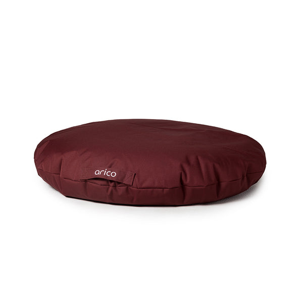 Coussin de sol de couleur bordeaux sur fond blanc. 