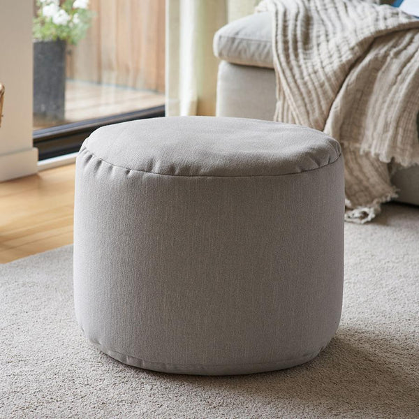 Pouf repose-pieds Arico de couleur bouleau dans un décor maison. 