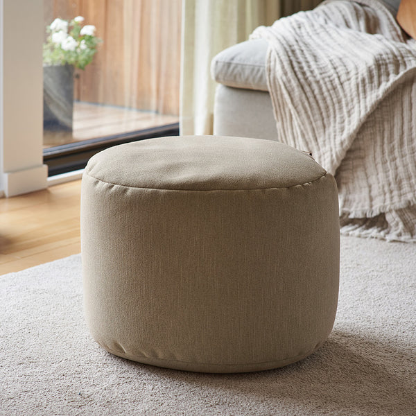 Pouf repose-pieds Arico de couleur sahara dans un décor maison. 