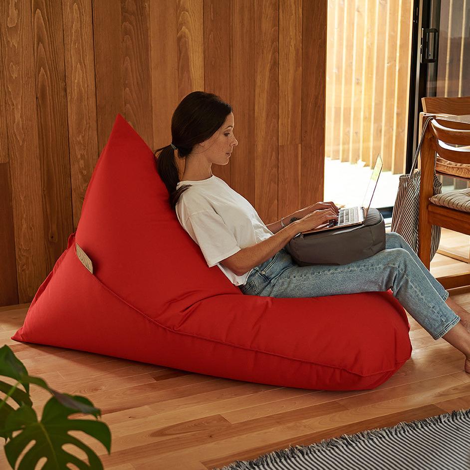 bean bag lounge adulte ARICO de couleur Chili avec femme qui fait la lecture avec le plateau coussin RICO.
